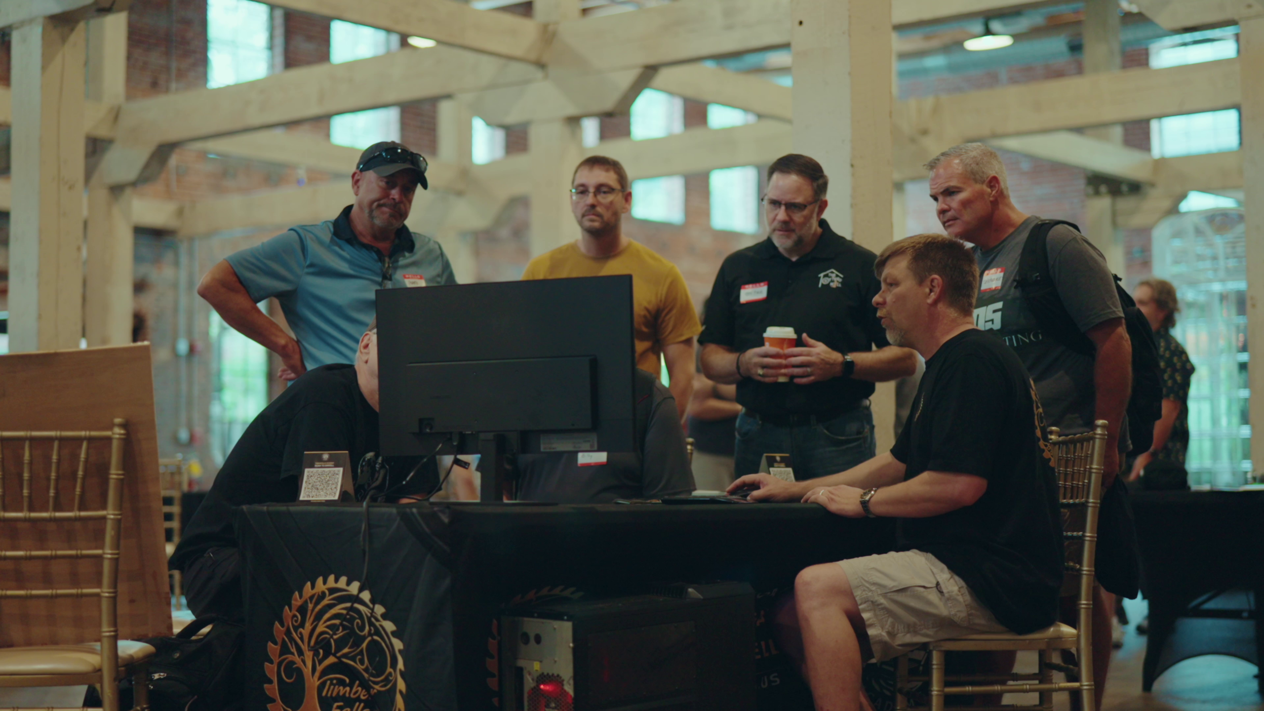 A small group of attendees gather around a workstation to look at a design on screen at the Carveco User Group