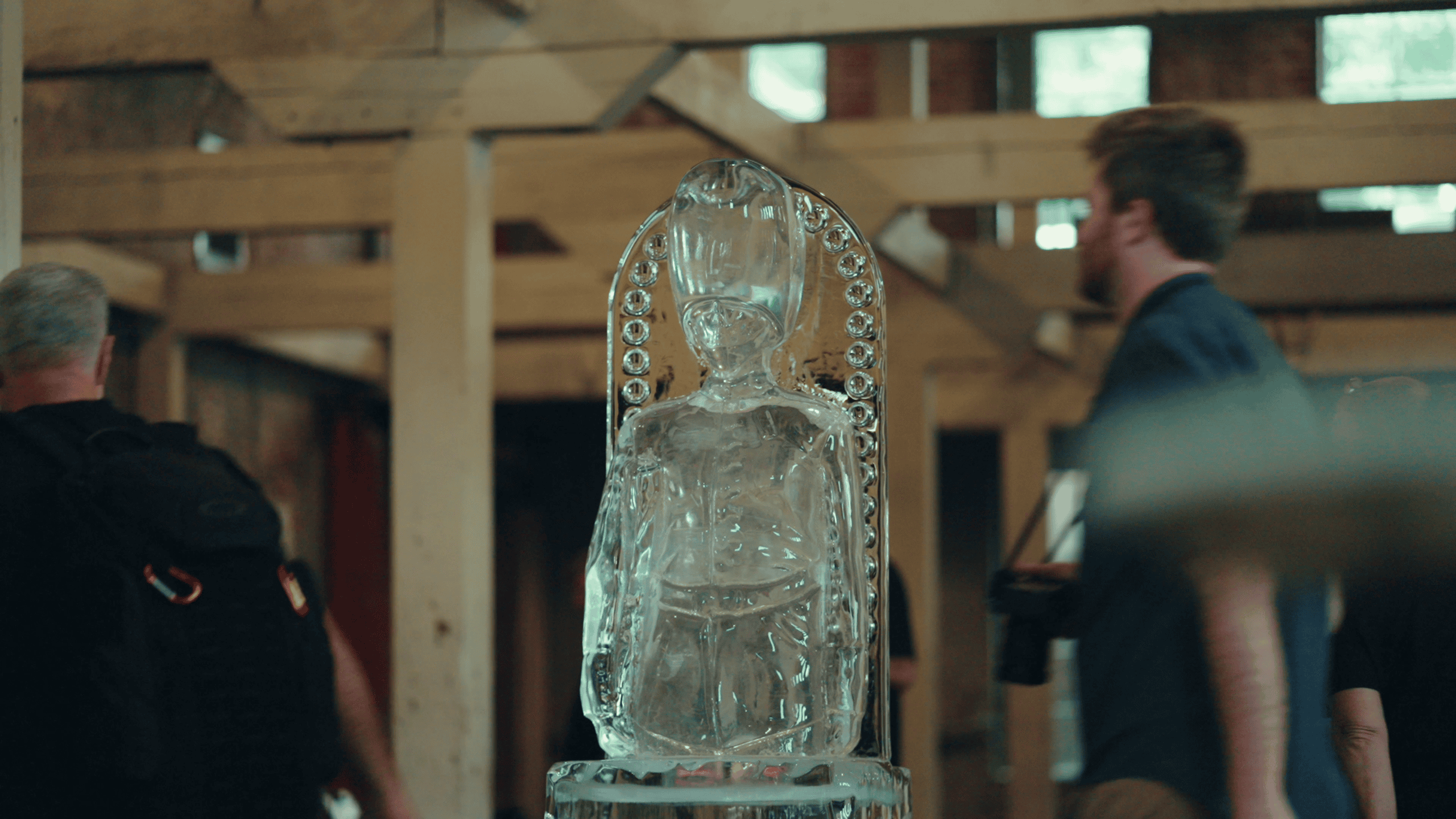 An ice sculpture of a King's Guard figure on display at Carveco User Group, with attendees passing by in the background