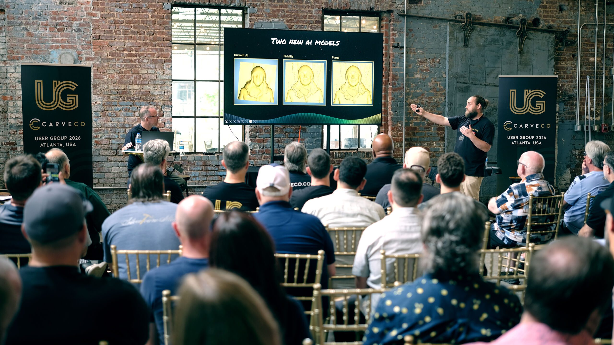 A presenter gestures toward a screen showing 'Two New AI Models,' comparing carved relief results from the current AI, Fidelity, and Forge models, in front of a seated audience