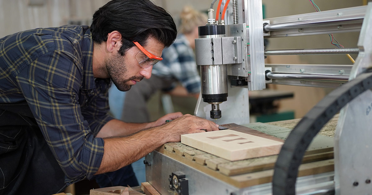 A carpenter staring at his work on a CNC machine